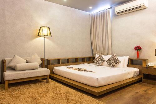 a hotel room with a bed and a chair at Valentine Hotel in Ho Chi Minh City