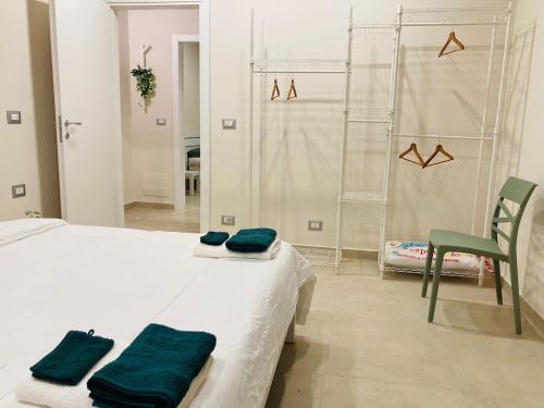 a white bedroom with a bed and a chair at La Dama B Piazza Bengasi in Moncalieri