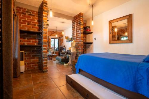 a bedroom with a blue bed and a brick wall at Cozy House with Pool and 3 Bedrooms in Yautepec