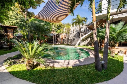 a swimming pool in a yard with palm trees at Cozy House with Pool and 3 Bedrooms in Yautepec