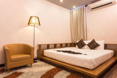 a bedroom with a bed and a chair at Valentine Hotel in Ho Chi Minh City