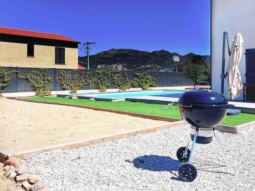 - un barbecue installé en face d'une piscine dans l'établissement Belle villa Amanduli avec piscine, à Calenzana