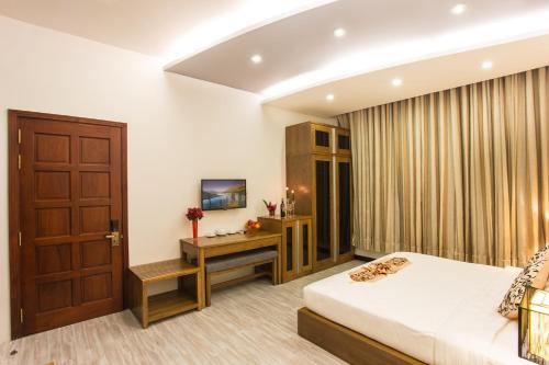 a bedroom with a bed and a wooden door at Valentine Hotel in Ho Chi Minh City