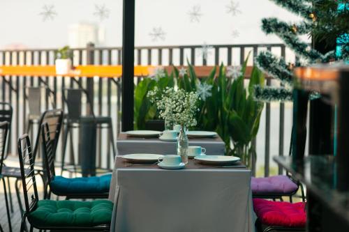 a table with a vase of flowers on a balcony at Westlake Pearl Apartment - Hotel & Pearl Spa in Hanoi