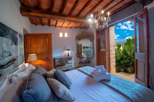 パンツァーノにあるMy Exclusive Italy - Chianti's Villa with vineyard, infinity pool & viewの大きなベッドと大きな窓のある寝室