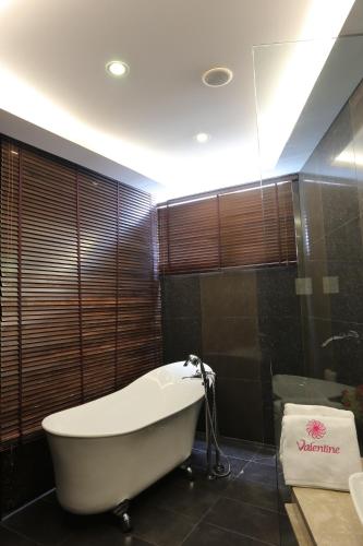 a bathroom with a bath tub and a shower at Valentine Hotel in Ho Chi Minh City