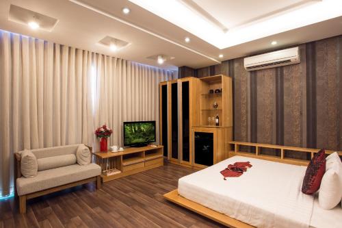 1 dormitorio con 1 cama, 1 silla y TV en Valentine Hotel, en Ho Chi Minh