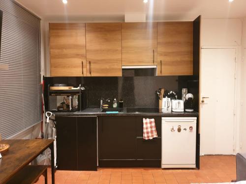 une cuisine avec des armoires en bois et un réfrigérateur blanc dans l'établissement Fabulous Paris F2 Champs-Elysées, à Paris