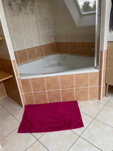 un tapis rouge au sol d'une douche dans l'établissement Jolie maison cosy proche plage & cité de la voile, à Larmor-Plage
