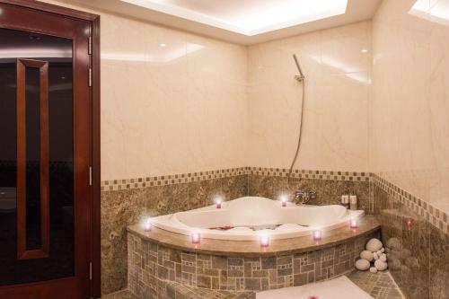 a bathroom with a tub with candles in it at Valentine Hotel in Ho Chi Minh City