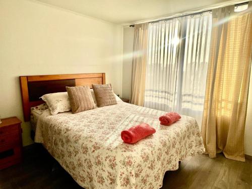 a bedroom with a bed with two red towels on it at Departamento 2D en Iquique!!! in Iquique