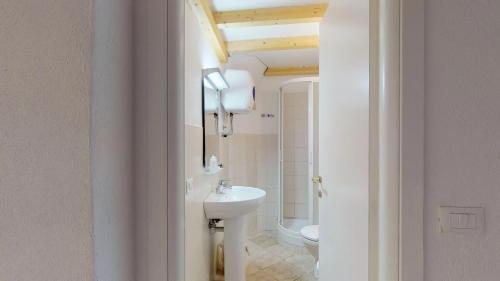 a white bathroom with a sink and a toilet at Casa del Teatro in Borgio Verezzi
