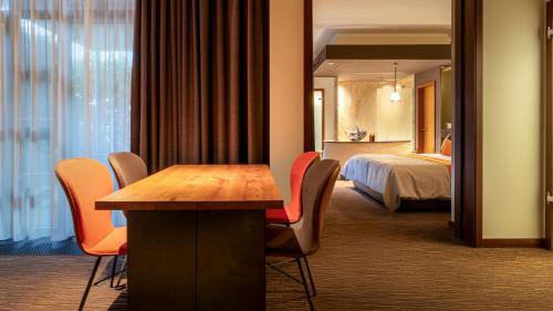 a hotel room with a table and chairs and a bed at east Hotel Hamburg in Hamburg