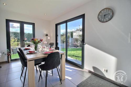 une salle à manger avec une table et une horloge au mur dans l'établissement La maison de margot, à Saint-Alban