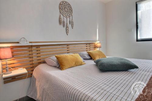 une chambre avec un lit avec deux oreillers dessus dans l'établissement La maison de margot, à Saint-Alban