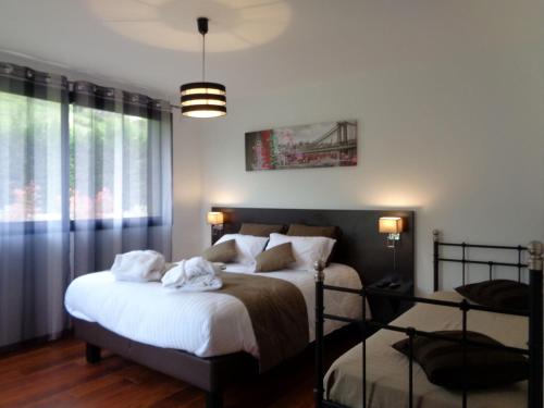 Un dormitorio con dos camas y una gran ventana. en Villa La Bénéchie, en Castang