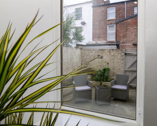 a view from a window of a patio with chairs at Bohemian Apartment, free WiFi and parking in New Brighton