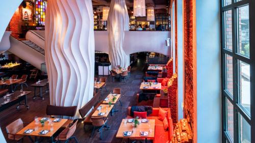 an overhead view of a restaurant with tables and chairs at east Hotel Hamburg in Hamburg