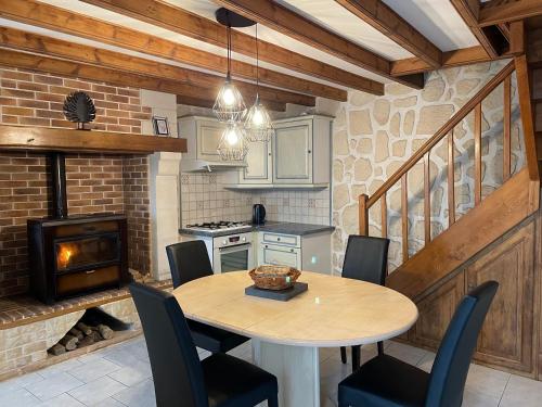 une cuisine avec une table et des chaises ainsi qu'une cheminée dans l'établissement Maison à Boutteville - Proche Ste Mère Eglise, à Boutteville