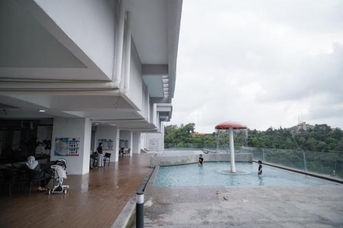 a swimming pool with an umbrella in the middle of a building at Melati Homestay in Kuala Terengganu