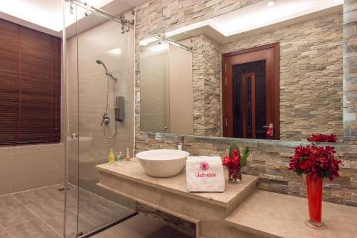 a bathroom with a sink and a shower at Valentine Hotel in Ho Chi Minh City