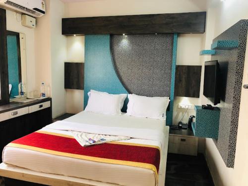 a bedroom with a large bed with a blue headboard at Joy Lux Stay in Bengaluru