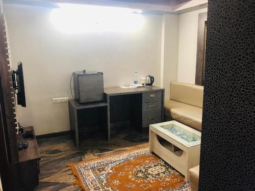 a small room with a desk and a tv at Joy Lux Stay in Bengaluru
