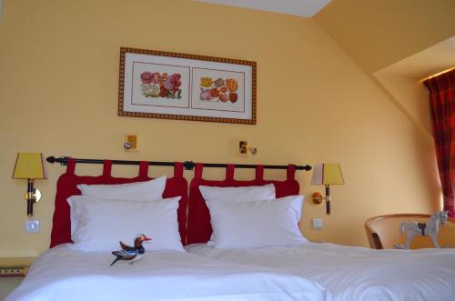 Кровать или кровати в номере Logis Hôtel Auberge du Cheval Blanc