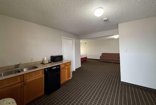 a room with a kitchen with a sink and a couch at Days Inn by Wyndham San Antonio Interstate Hwy 35 North in San Antonio