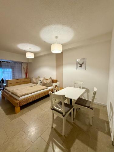 a bedroom with a bed and a table and chairs at RELAX Seefeld Apartman in Seefeld in Tirol