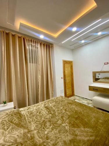 a bedroom with a large bed in front of a window at Appartement Les Vagues Bleues in Monastir