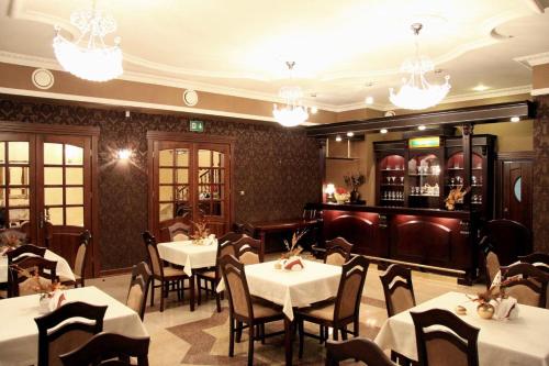 um restaurante com mesas e cadeiras e um bar em Kryształowy Pałacyk em Kozienice