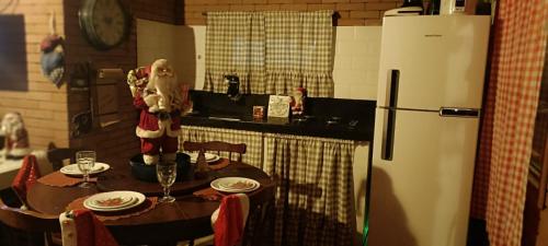 a kitchen with a table and a refrigerator at Rancho Chalé Vila Gostoso in Touros
