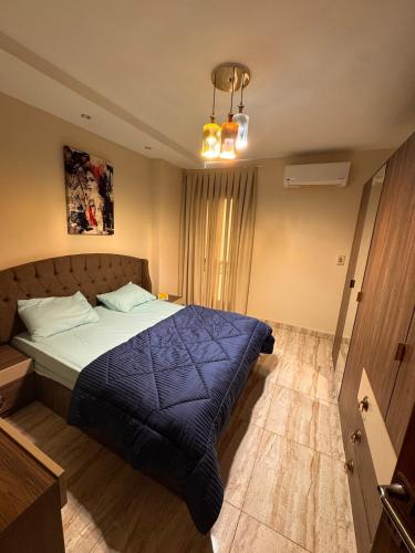 a bedroom with a bed with a blue comforter at Luxury apartment b3 Mdinaty in Madinaty