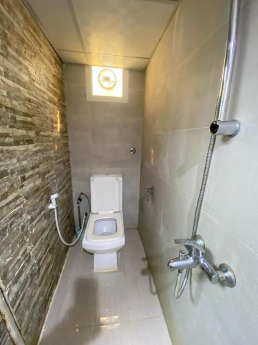 a small bathroom with a toilet and a window at 007 - Farmhouse 8 in Abu Dhabi