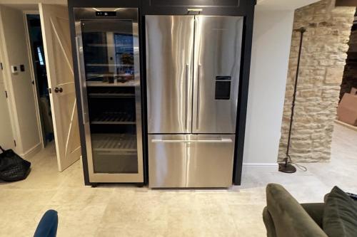 - un réfrigérateur en acier inoxydable dans le salon dans l'établissement Stunning Cotswolds Cottage 5 min from Soho Farmhouse, à Enstone