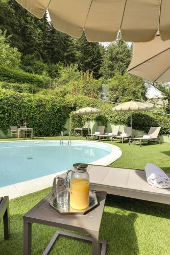 a drink on a table next to a swimming pool at My Exclusive Italy - Entire Hilltop Villa with Private Pool in Palazzuolo sul Senio