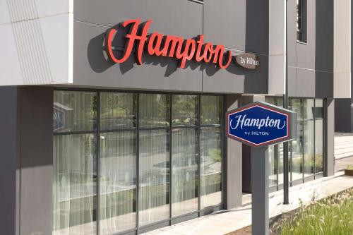a sign in front of a hampota store at Hampton By Hilton Malaga Martiricos in Málaga