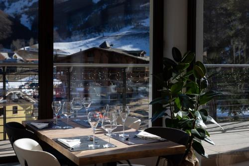 a table with wine glasses and a large window at Riserva Bianca Limone Hotel & SPA in Limone Piemonte