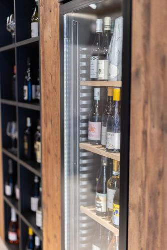 a refrigerator filled with lots of bottles of alcohol at Riserva Bianca Limone Hotel & SPA in Limone Piemonte