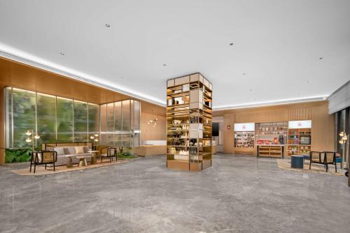 a lobby of a building with chairs and tables at Hilton Garden Inn Xuzhou Pengcheng Square in Xuzhou