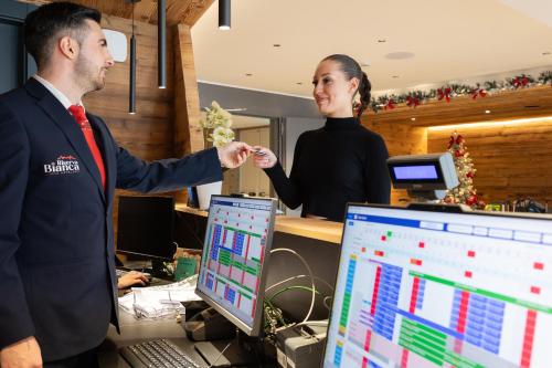 a man and a woman standing in an office at Riserva Bianca Limone Hotel & SPA in Limone Piemonte