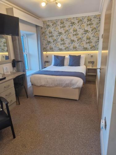 a bedroom with a bed with blue pillows and a desk at The Quay lodge in Wexford