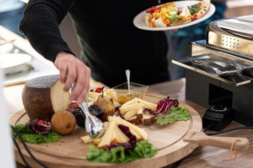 a person preparing a plate of food on a cutting board at Riserva Bianca Limone Hotel & SPA in Limone Piemonte