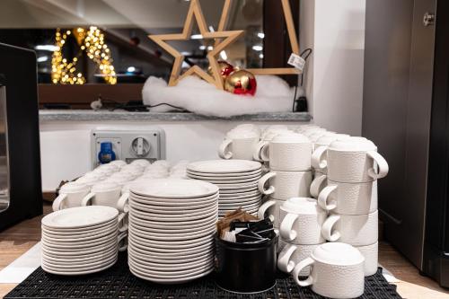 a pile of white plates and cups on a table at Riserva Bianca Limone Hotel & SPA in Limone Piemonte