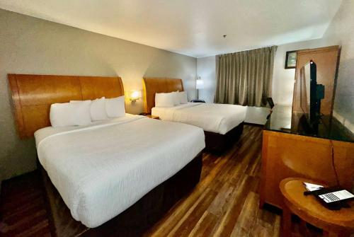 une chambre d'hôtel avec deux lits et une télévision dans l'établissement Baymont by Wyndham Missoula, à Missoula
