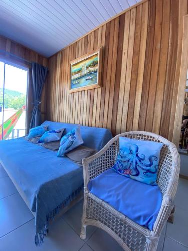 a wicker bed and a chair in a room at Casa Aluguel Porto Belo in Porto Belo
