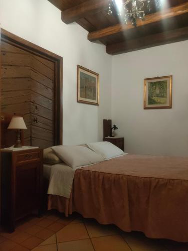 a bedroom with a bed and a table and a lamp at Il Cortile del Castello in Capena