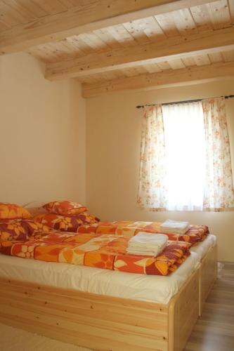 a bedroom with a bed and a window at BONI APARTMAN Hegykő in Hegykő