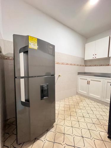 a kitchen with a stainless steel refrigerator in a room at Habitación privada apartamento in Santa Marta